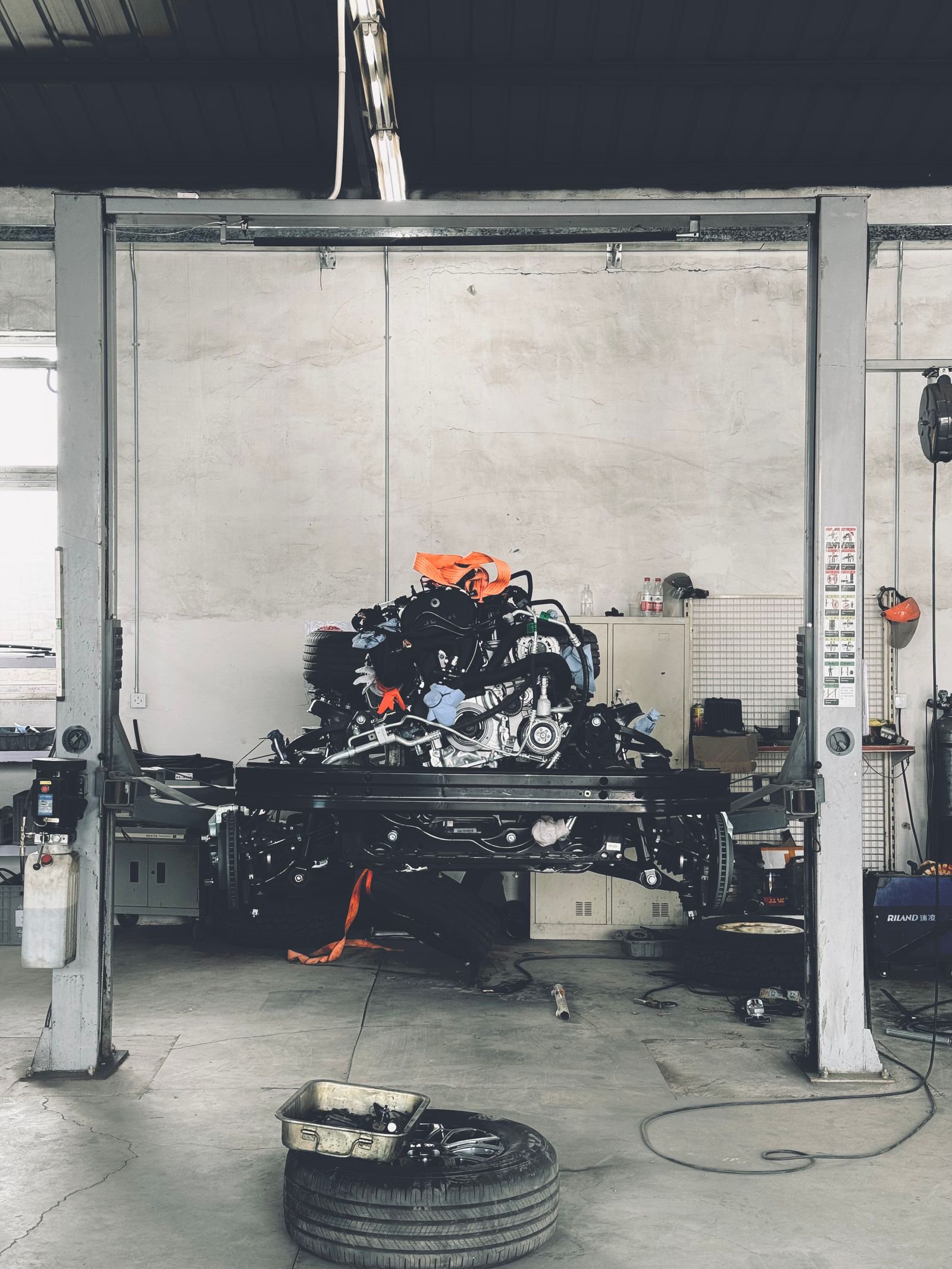 Vehicle chassis and engine positioned on a workshop lift